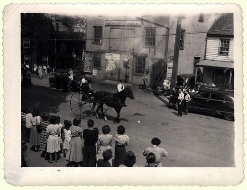 Ancient Sulky in front of A. B. Lord’s Blacksmith shop and Coella house. This sulky is reputed to have be used and pulled by Hambletonian. 100th Hambletonian Anniversary Parade, May 5, 1949. chs-003472